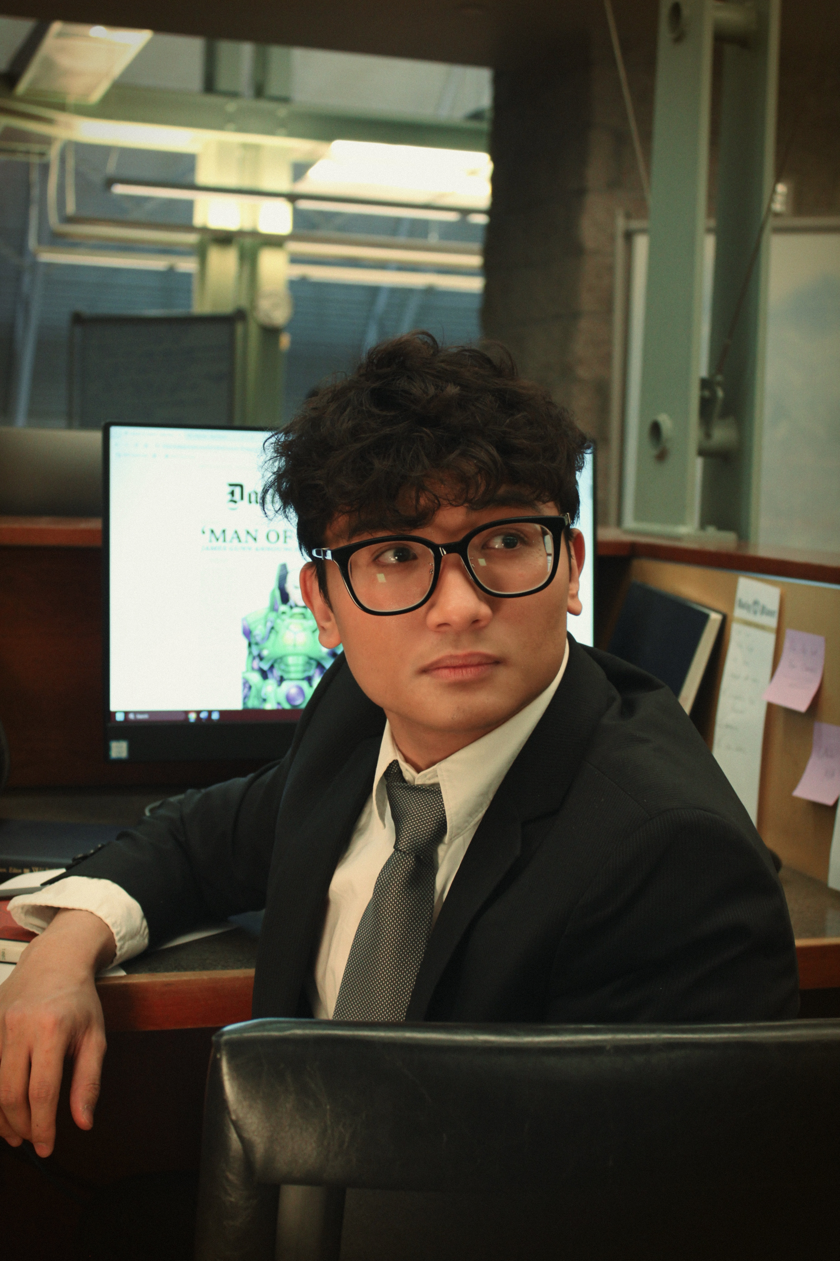 Cinematic seated portrait of Mark Jayson Farol in officewear.